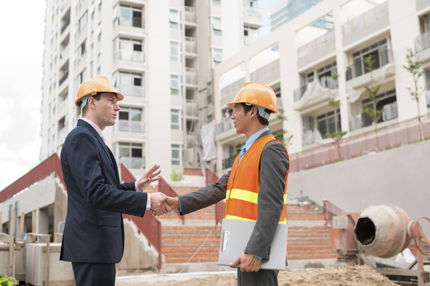 Businessman meeting Asian engineer at the construction site